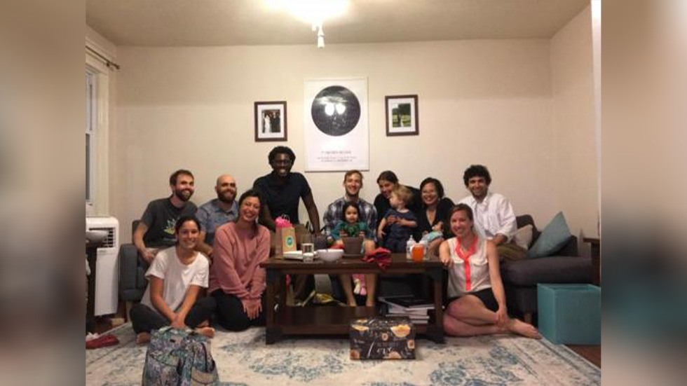 group of people posing for a photo on and around a couch